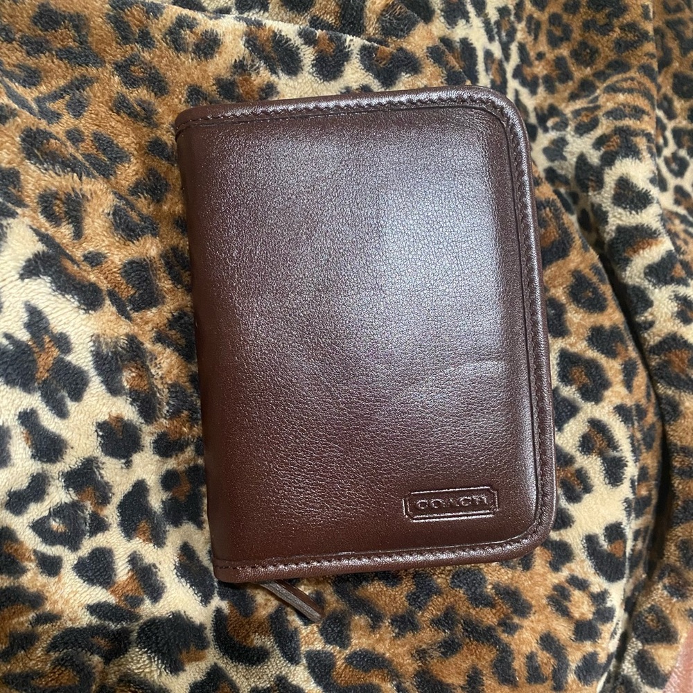 Brand new COACH passport holder. Never been used. Brown leather.